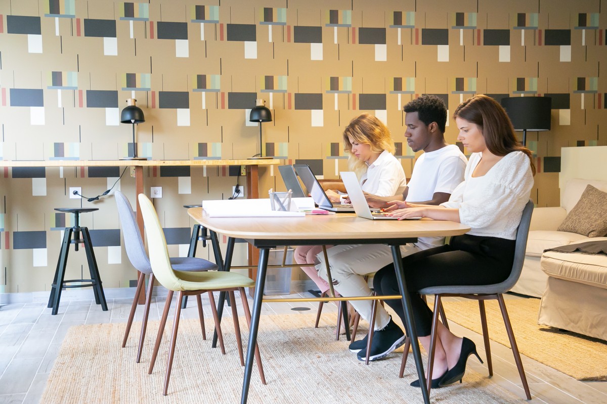 Team of designers using dedicated desks at a co-working space Team of designers using dedicated desks at a co-working space