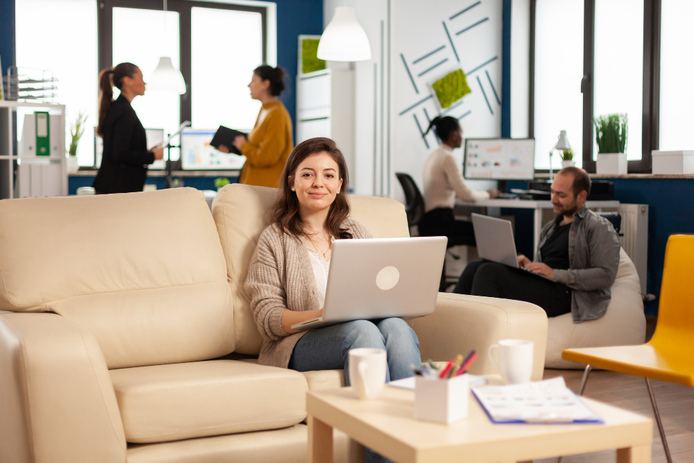 Entrepreneur working on laptop with team in co-working space